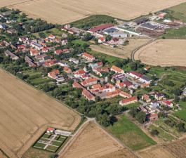 Labības lauku ieskautas mazpilsētas skats no putna lidojuma vasaras dienā